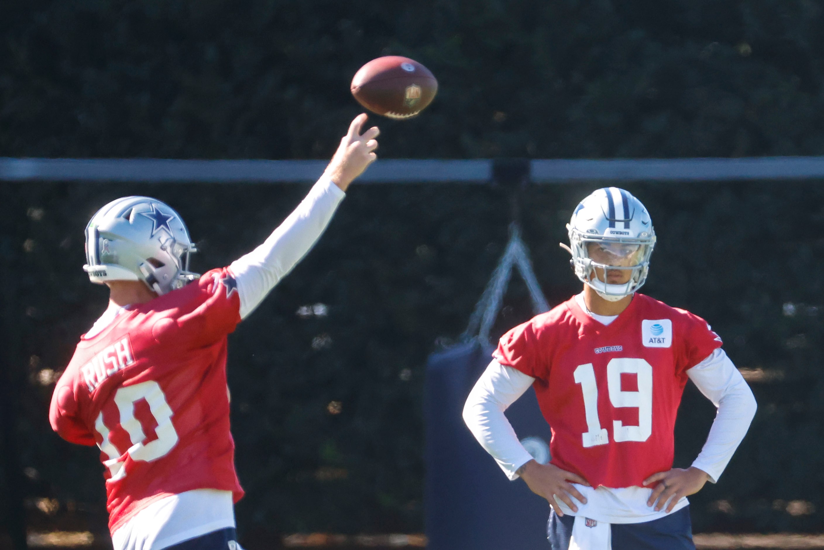 Dallas Cowboys quarterback Cooper Rush (left) throws as  quarterback Trey Lance follows...