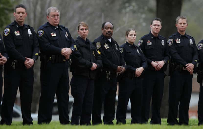 About 30 police officers, mostly from Irving, stood silently outside the Walls Unit in...