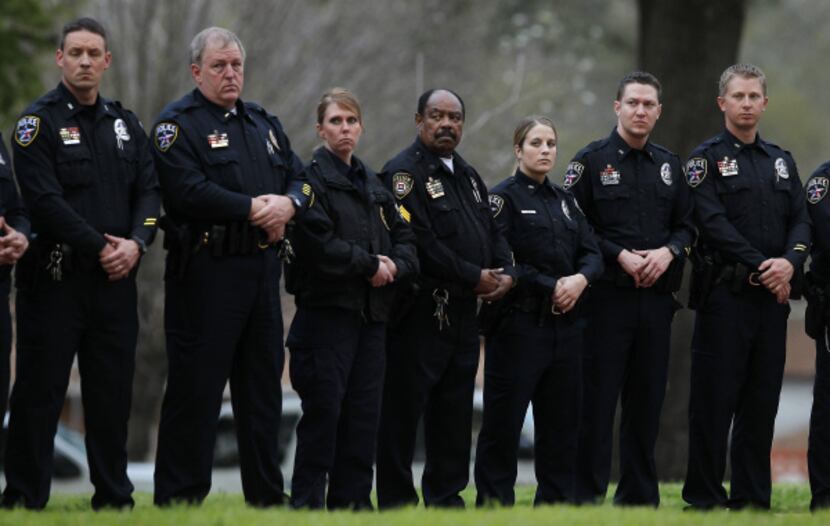 About 30 police officers, mostly from Irving, stood silently outside the Walls Unit in...