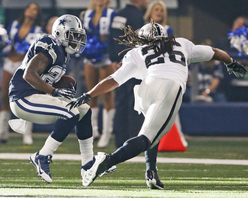 Dallas Cowboys running back Lance Dunbar (25) tries to elude Oakland Raiders free safety...
