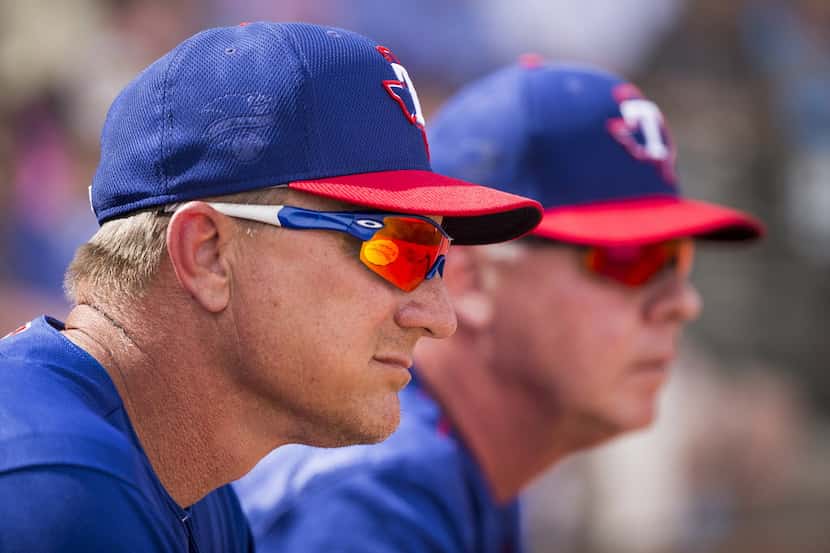 Texas Rangers manager Jeff Banister and bench coach Steve Buechele watch a spring training...