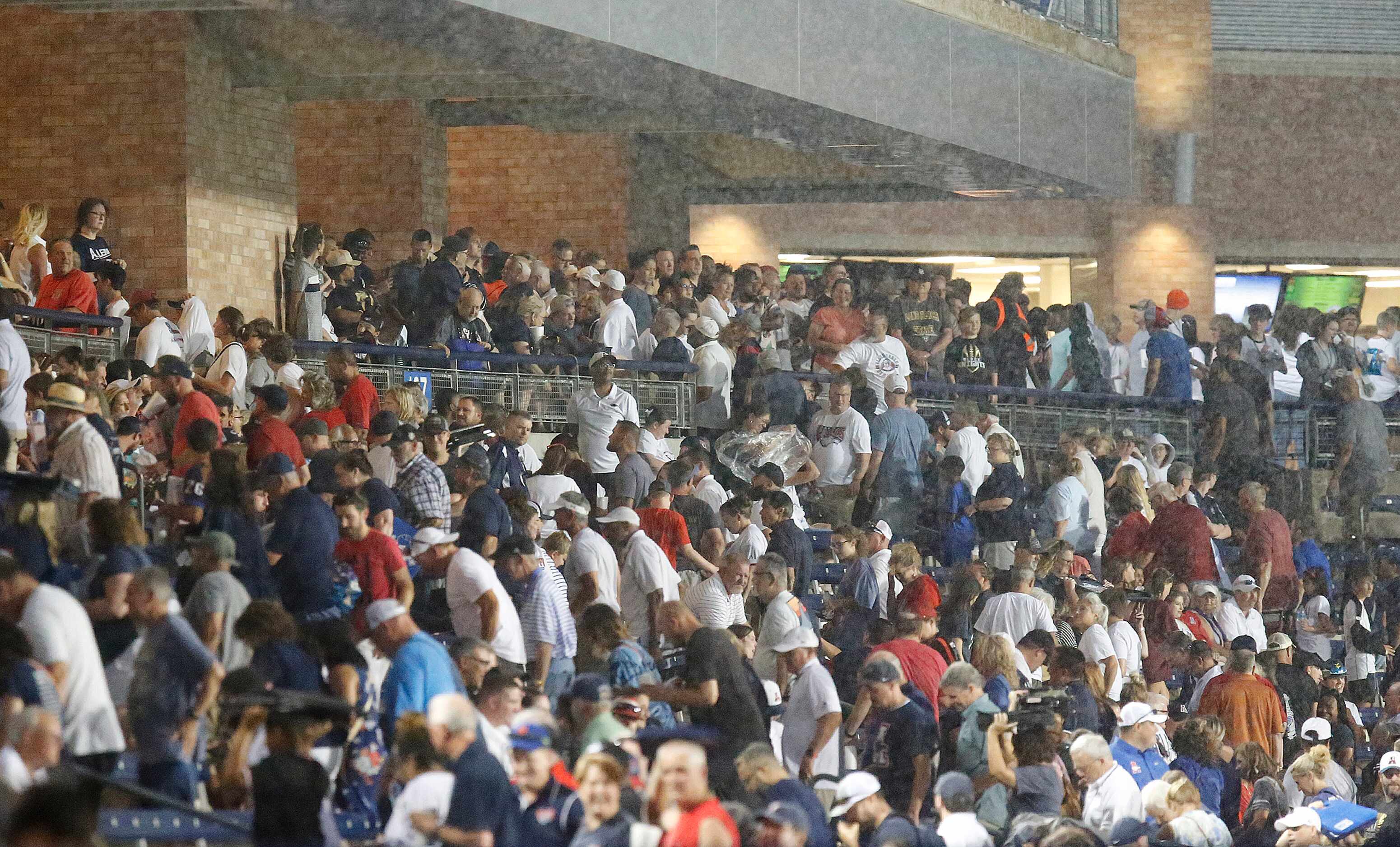 Allen Eagle fans head for cover as the downpour started during the first half as Allen High...
