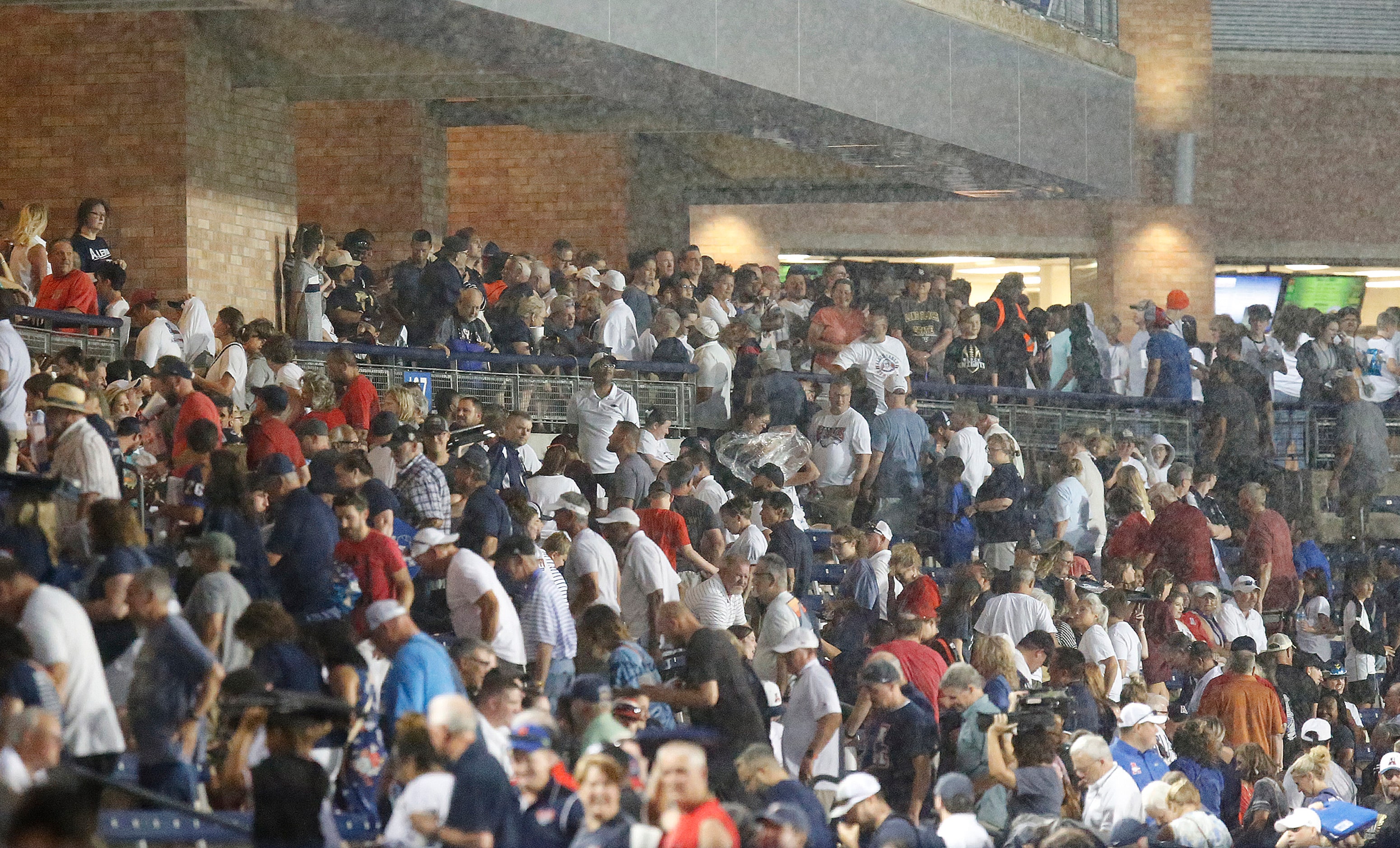 Allen Eagle fans head for cover as the downpour started during the first half as Allen High...