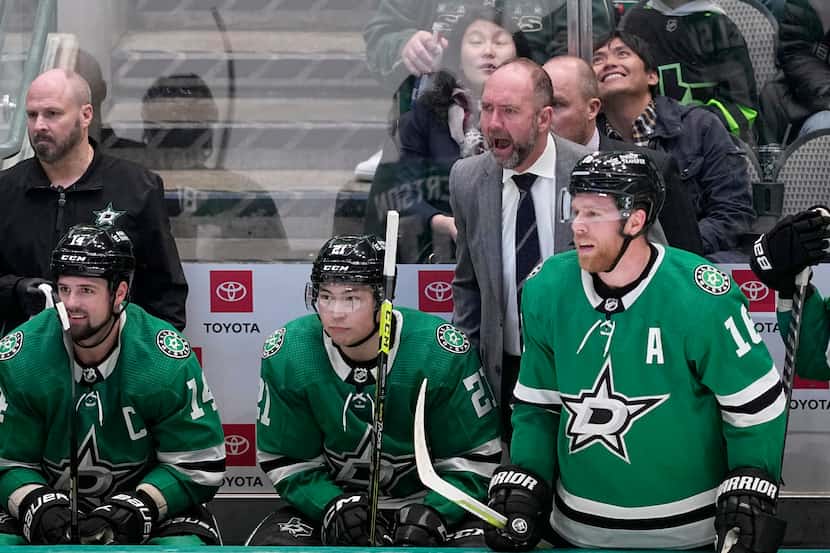 Dallas Stars head coach Pete DeBoer, right rear, yells at an official standing nearby as...