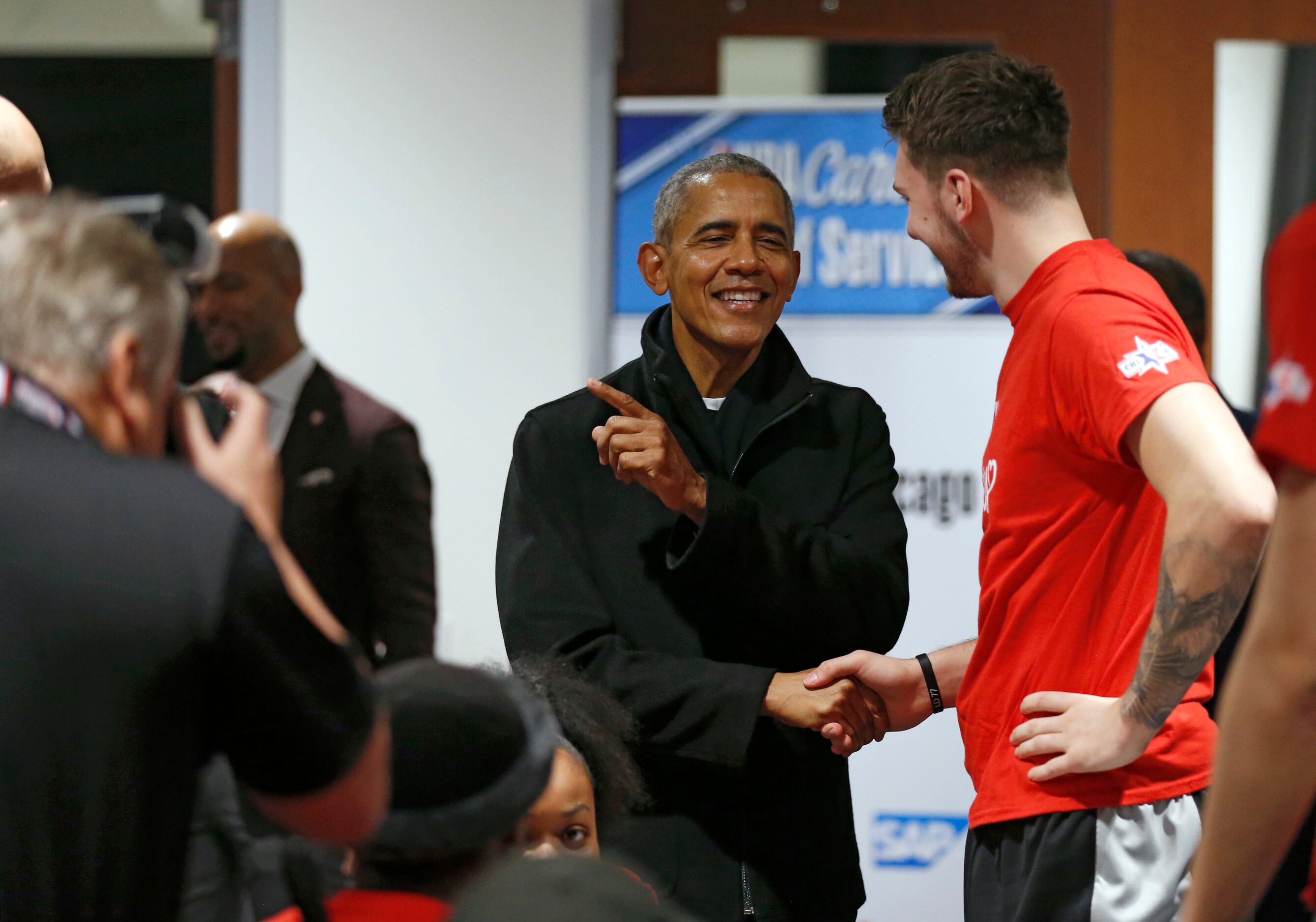 Former President Barack Obama jokes with Los Angeles Lakers assistant coach Jason Kidd as he...