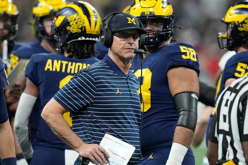 Michigan head coach Jim Harbaugh watches from the sidelines during the first half of the Big...