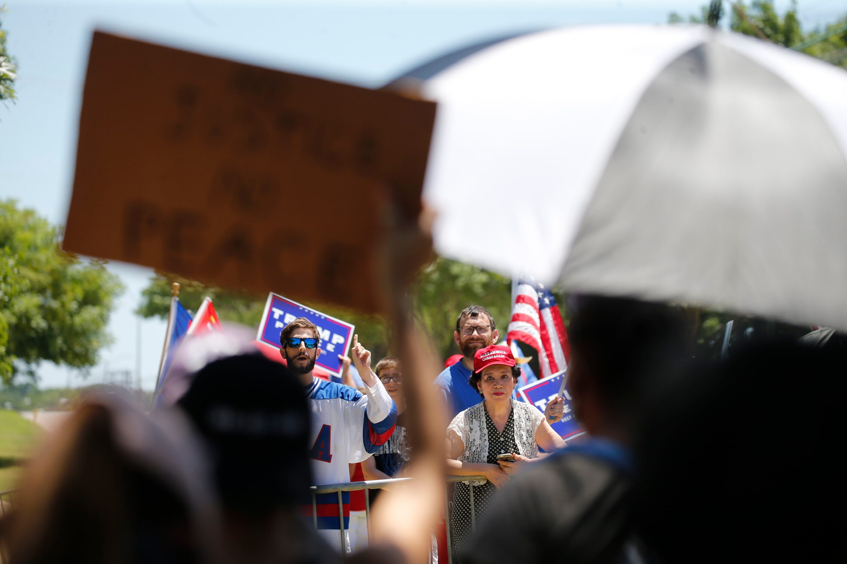 Anti-Trump protesters (foreground) and Trump supporters chant at each other across the...