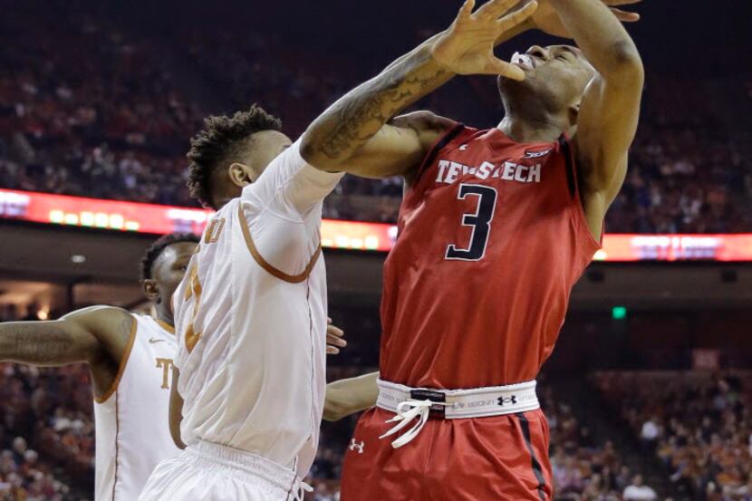 Texas Tech guard C.J. Williamson (3) is blocked by Texas guard Demarcus Holland (2) as he...