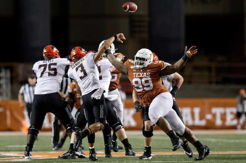 FILE - Oklahoma State quarterback Spencer Sanders (3) throws a pass under pressure by Texas...