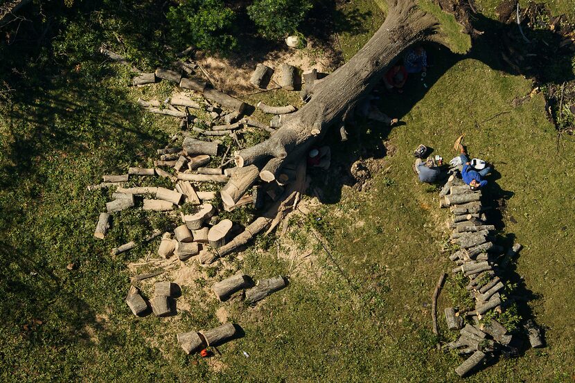 Workers rest while cutting up a downed tree near Walnut Hill Lane and Marsh Lane on the day...