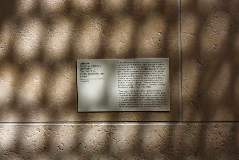 Shadows fall on the nameplate of a work of Jean Arp, as the reflected light off of Museum...