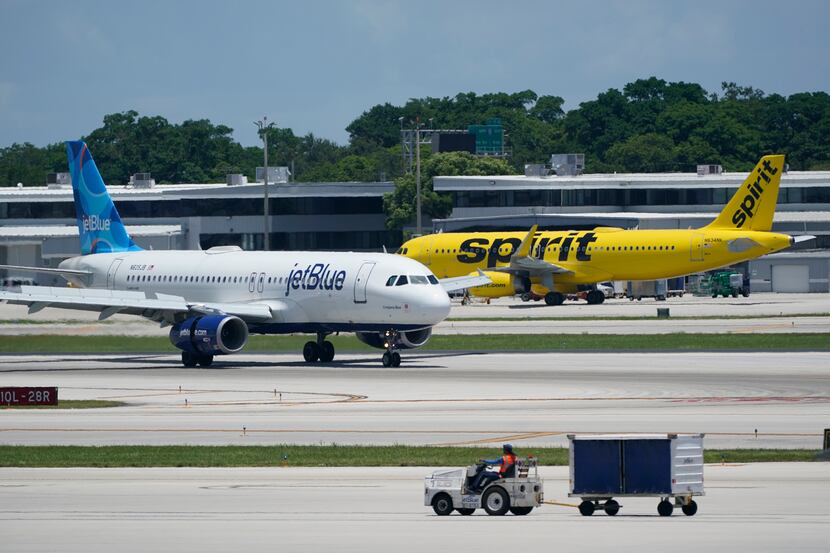 A JetBlue Airways Airbus A320, left, passes a Spirit Airlines Airbus A320 as it taxis on the...