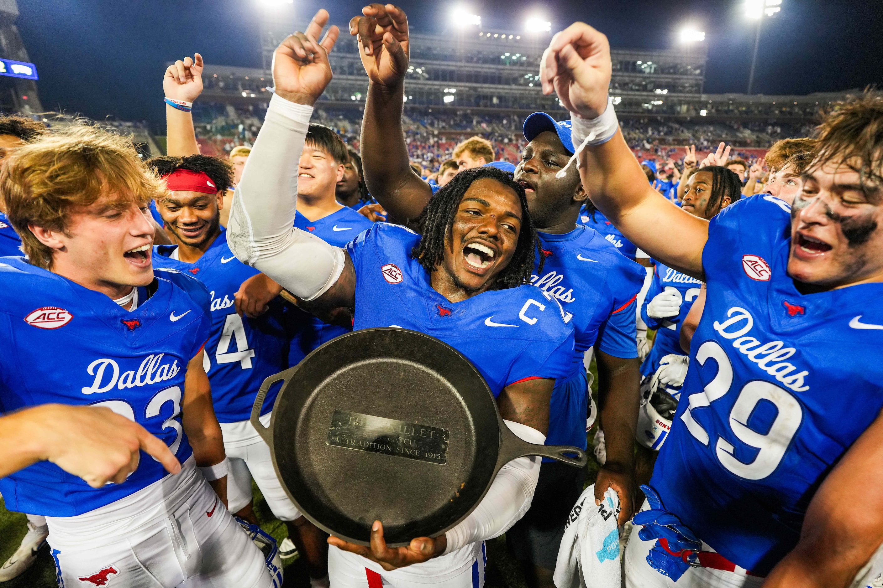 SMU linebacker Kobe Wilson holds the Iron Skillet trophy as the Mustangs celebrate after a...