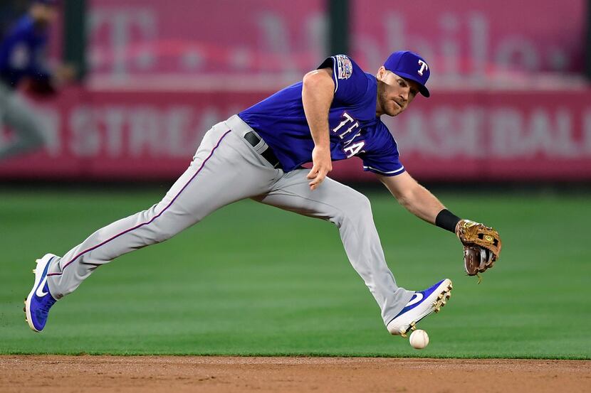 Texas Rangers second baseman Logan Forsythe can't handle a ball hit for a single by Los...