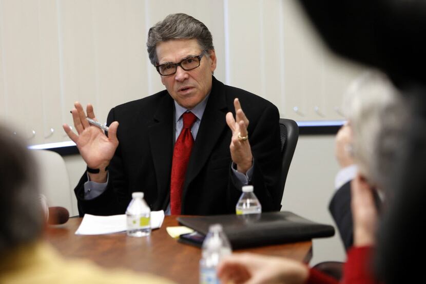 Former Texas Gov. Rick Perry talks with  Bedford, N.H., business leaders, during a Feb. 11...