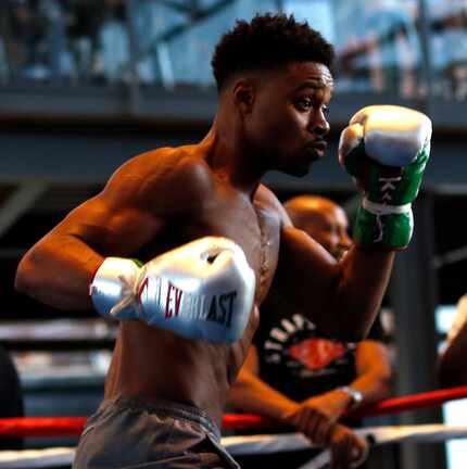 Errol Spence Jr. moves in to land a punch as he works out with trainer Derrick James before...