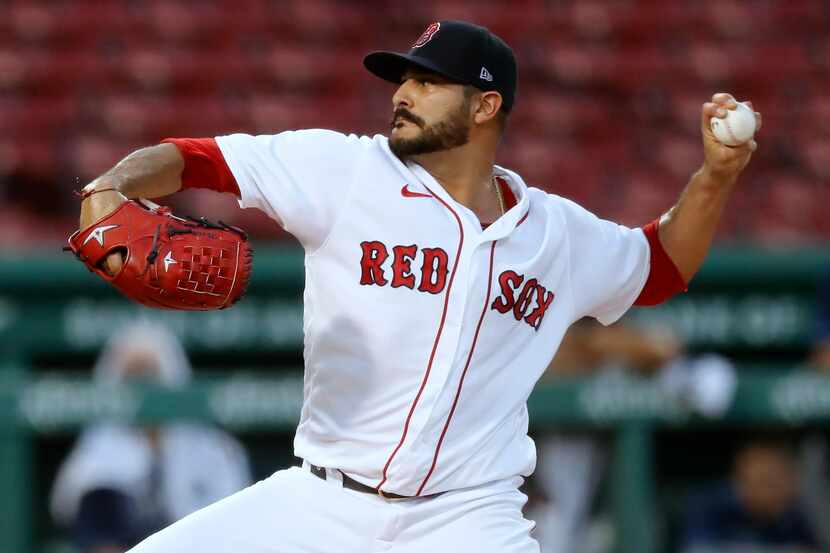 Former Boston Red Sox pitcher Martin Perez throws during the first inning of a baseball game...