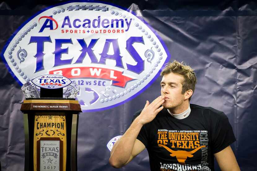 Texas punter Michael Dickson, the game MVP, kisses the championship trophy after a win over...