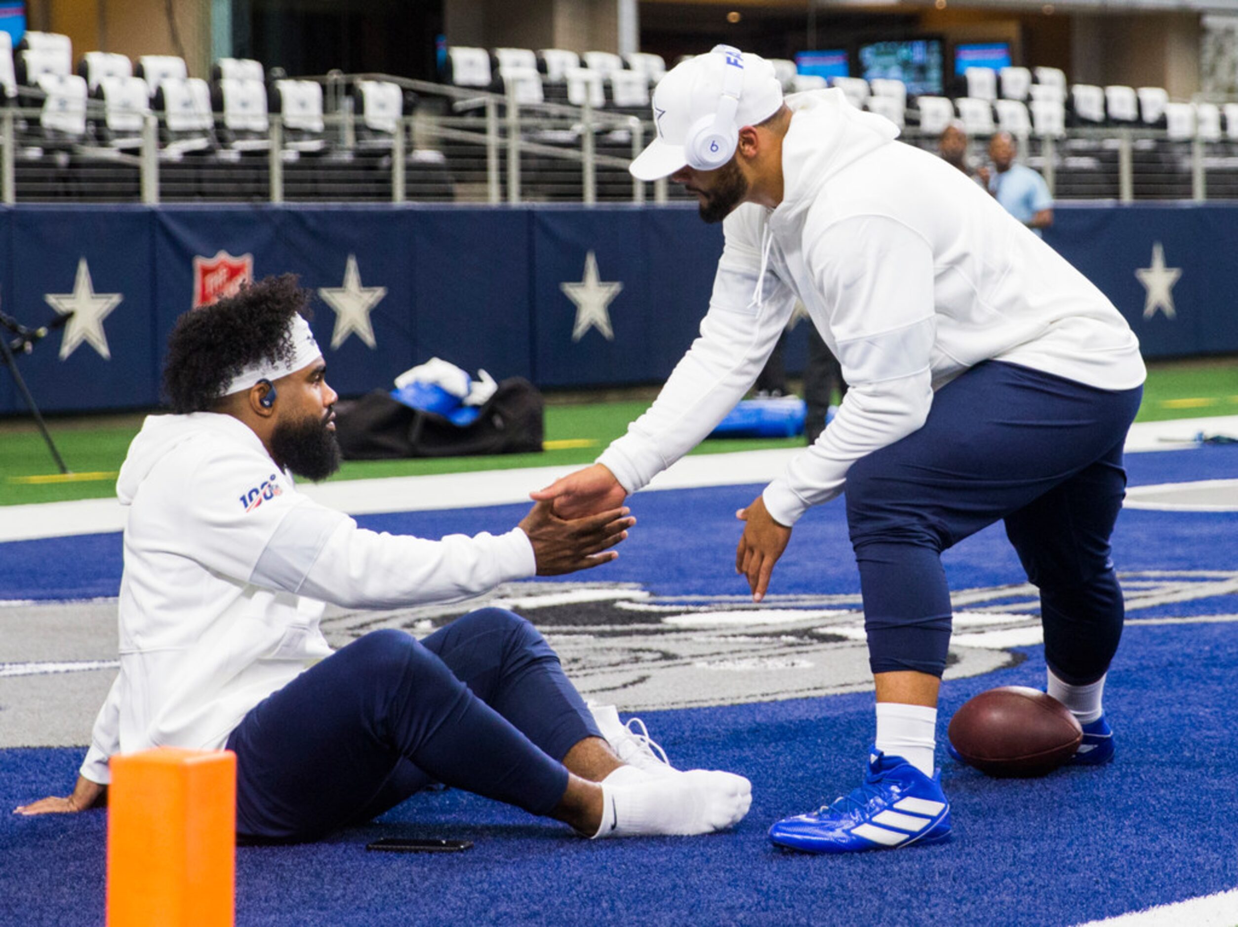 Dallas Cowboys quarterback Dak Prescott (4) greets running back Ezekiel Elliott (21) as they...