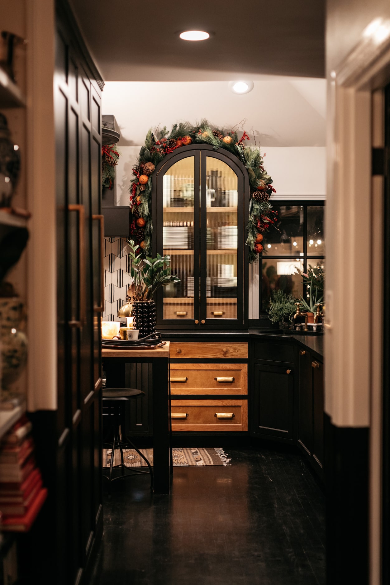 In the kitchen, Burkle hung faux garland layered with oranges, magnolia leaves, and...