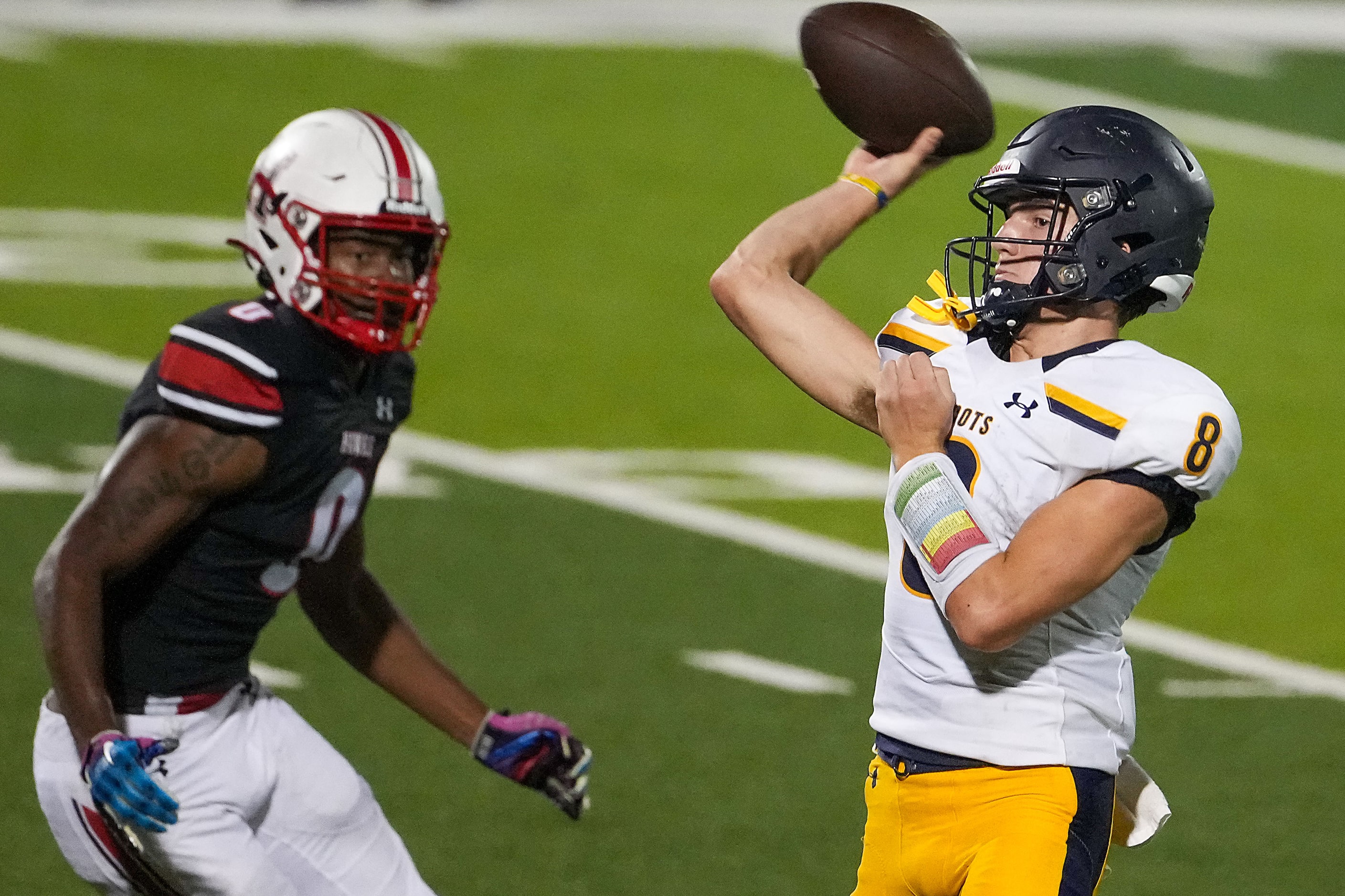 Highland Park quarterback Buck Randall (8) throws a pass under pressure from Rockwall-Heath...