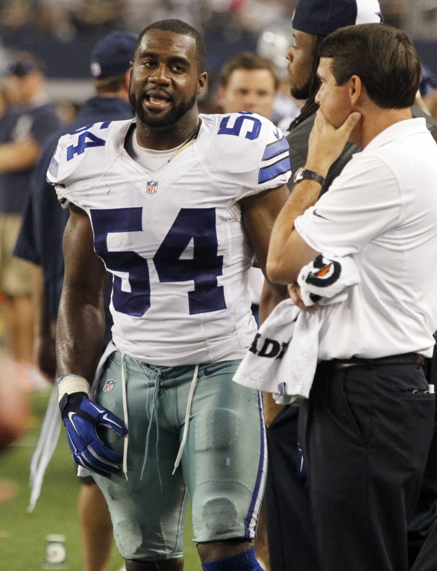 Dallas Cowboys outside linebacker Bruce Carter (54) on the sideline with something on his...