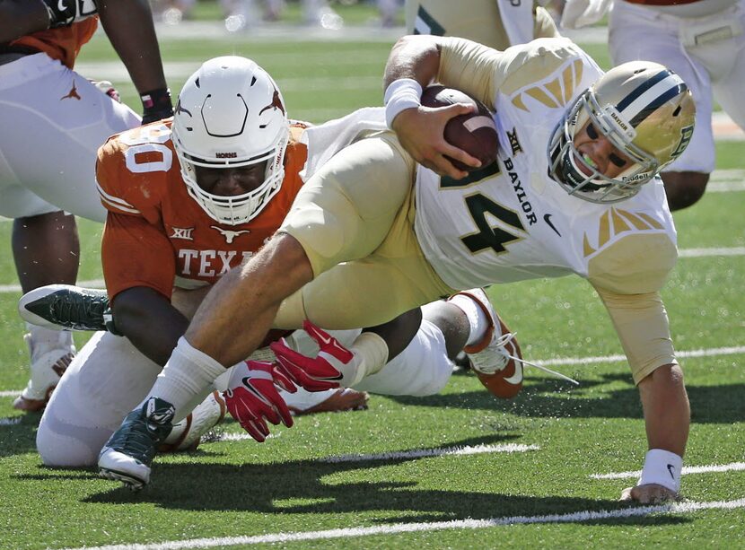 Baylor quarterback Bryce Petty (14) struggles for extra yardage near the goal line as Texas'...