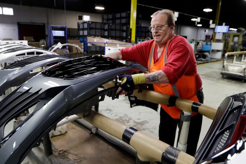 Clifford Goff, a bezel assembler, transfers a front end of a General Motors Chevrolet Cruze...
