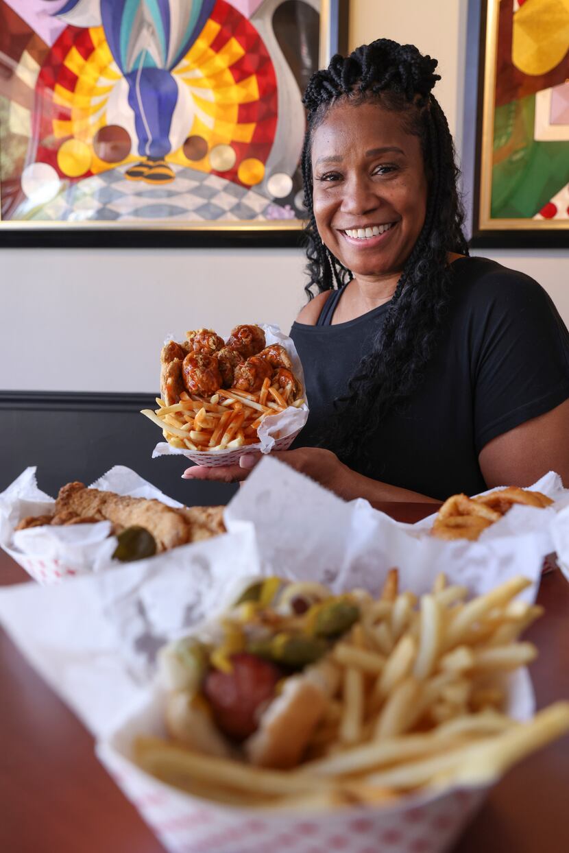Angela McCreary, owner of What’s Cluckin, holds some wings and fries. 