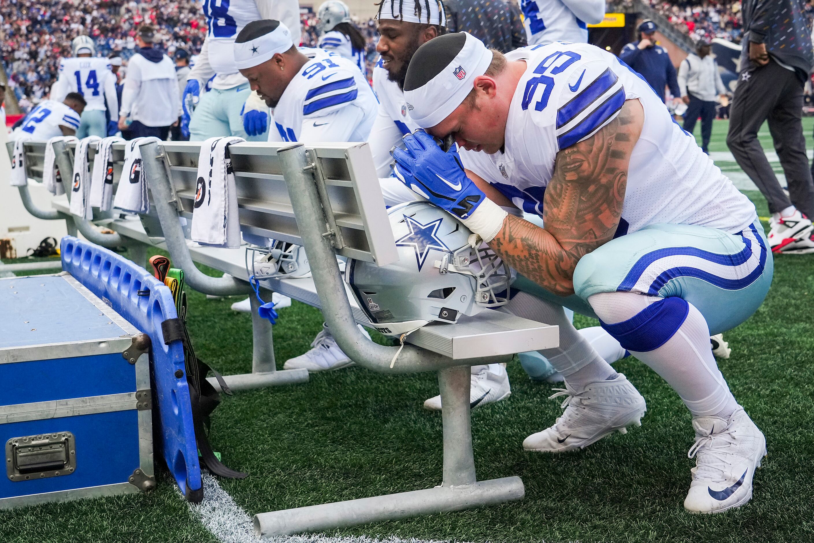 Dallas Cowboys defensive tackle Brent Urban (95) prays on the bench before an NFL football...