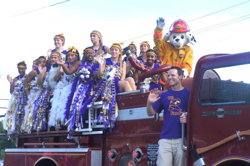 
The Richardson High School varsity cheerleaders smile and wave during the 2013 homecoming...