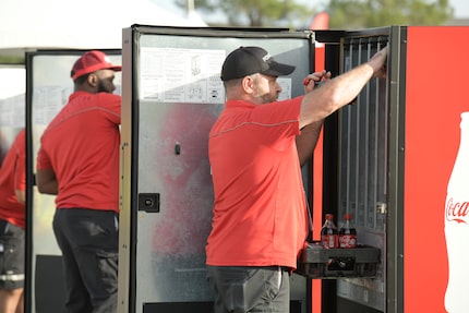 Merchandisers load drinks into Coca-Cola coolers as fast as they can to win the Merchandiser...