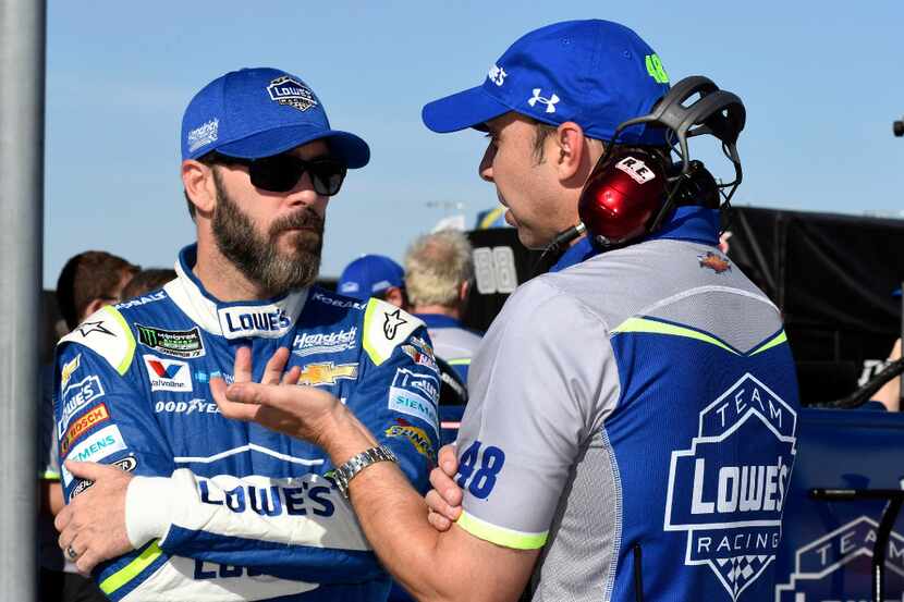Jimmie Johnson, left, talks with crew chief Chad Knaus on pit road during qualifying for...