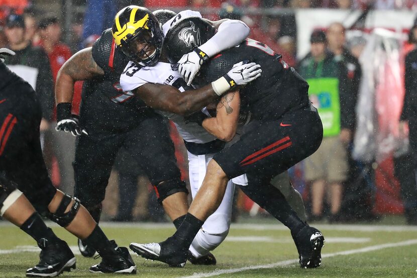 PISCATAWAY, NJ - OCTOBER 08:  Taco Charlton #33 of the Michigan Wolverines sacks Chris...