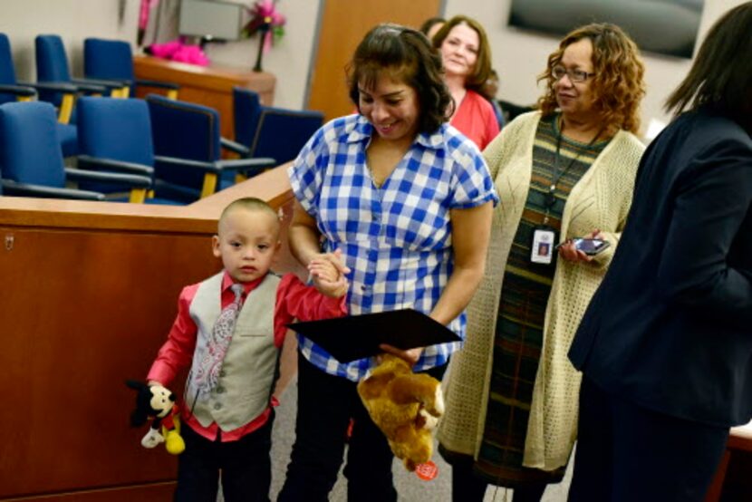 Sara Alicia Arévalo sale de la corte tomando la mano de su hijo adoptivo, Fernando, de tres...