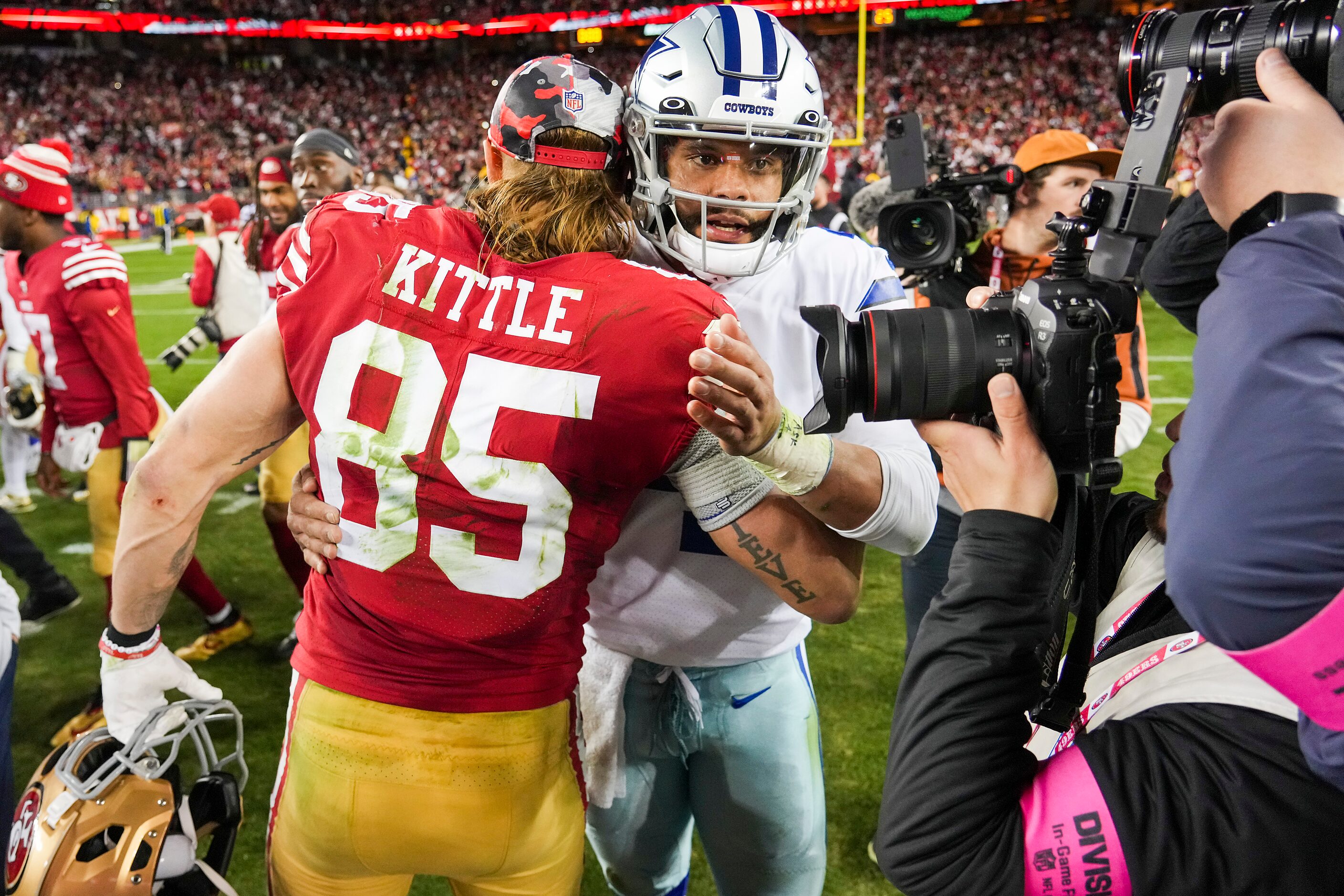 Dallas Cowboys quarterback Dak Prescott (4) hugs San Francisco 49ers tight end George Kittle...