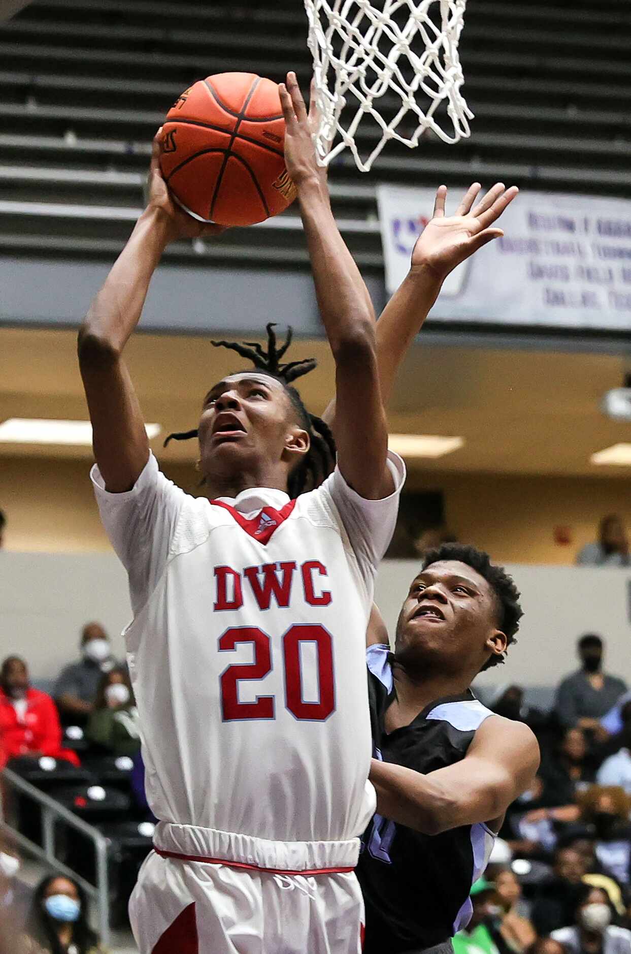 Carter forward Reece Bell (20) goes in for two points against Roosevelt forward Gunran King...