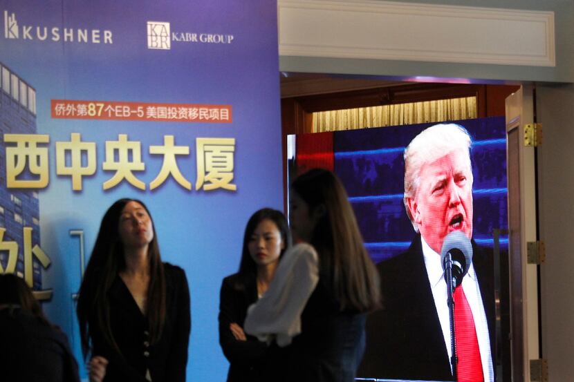 A projector screen shows a footage of U.S. President Donald Trump as workers wait for...