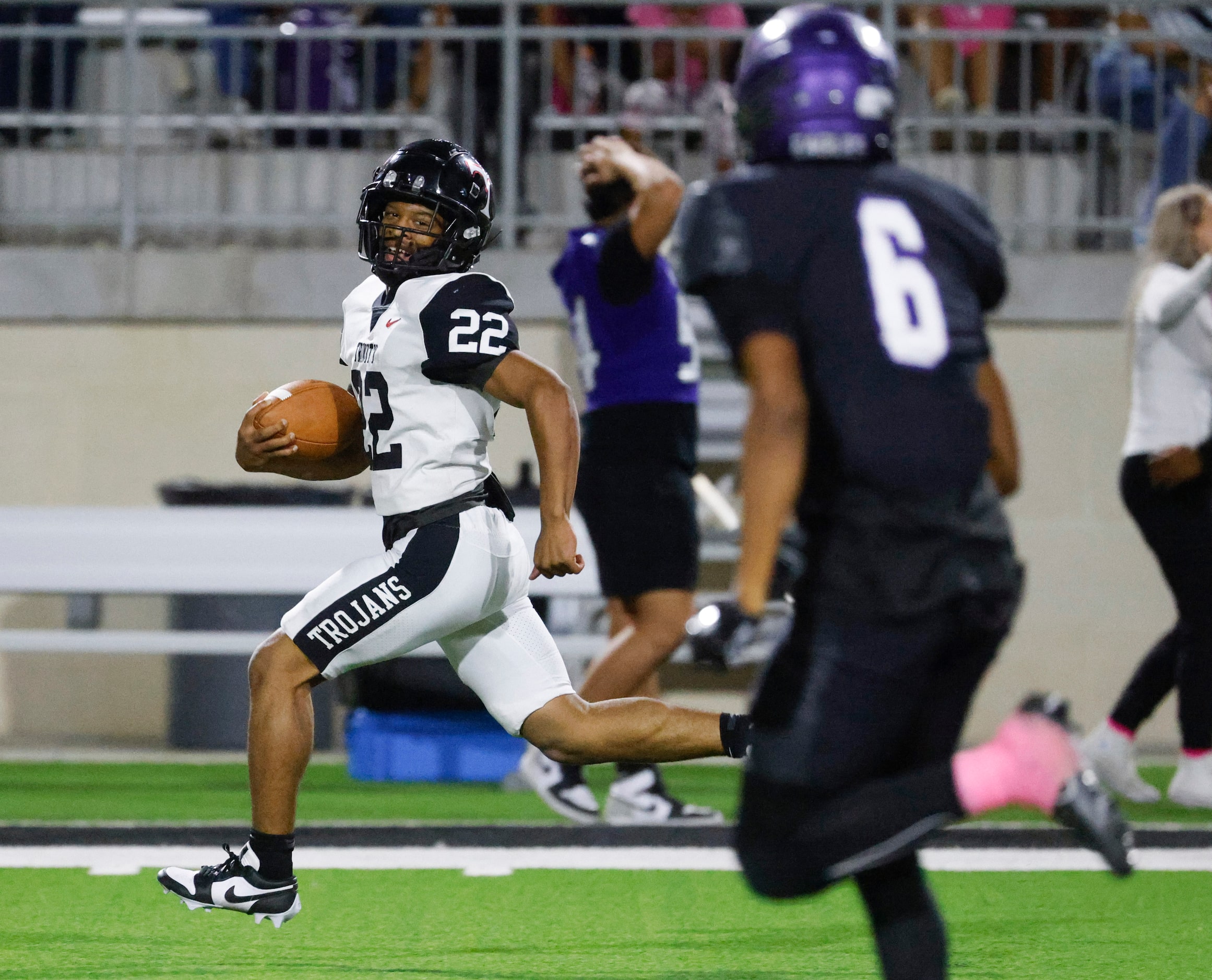 Trinity High’s JT Harris (22) looks back as he completes a run for a touchdown against...