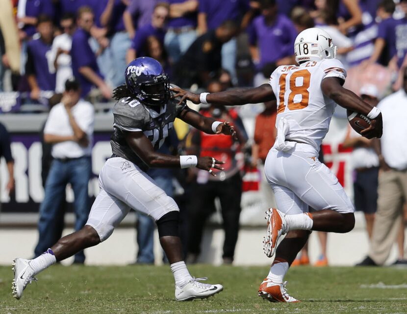 Texas Longhorns quarterback Tyrone Swoopes (18) tries to hold off TCU Horned Frogs safety...