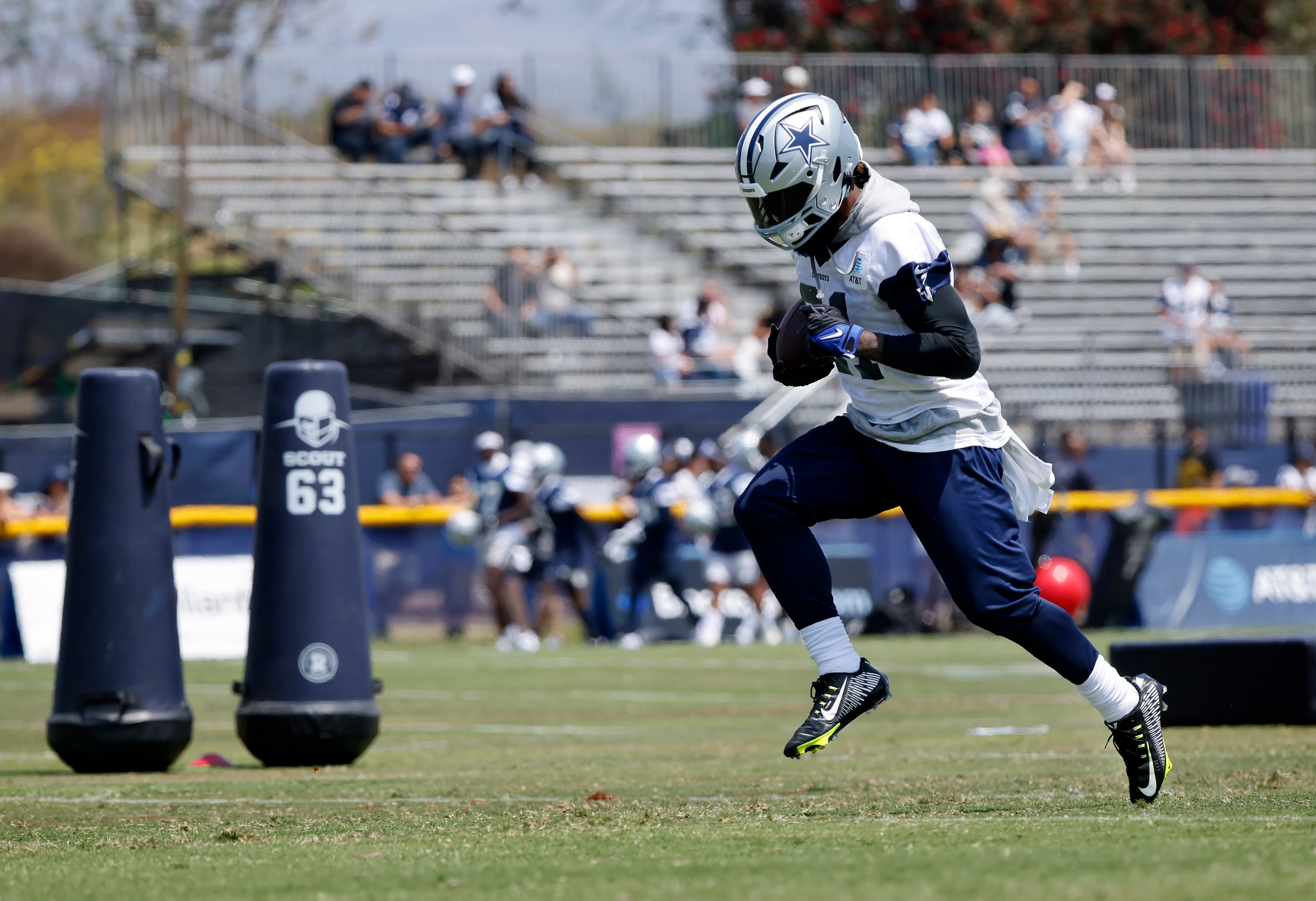 Dallas Cowboys running back Ezekiel Elliott (21) has a springing his top as he carries the...