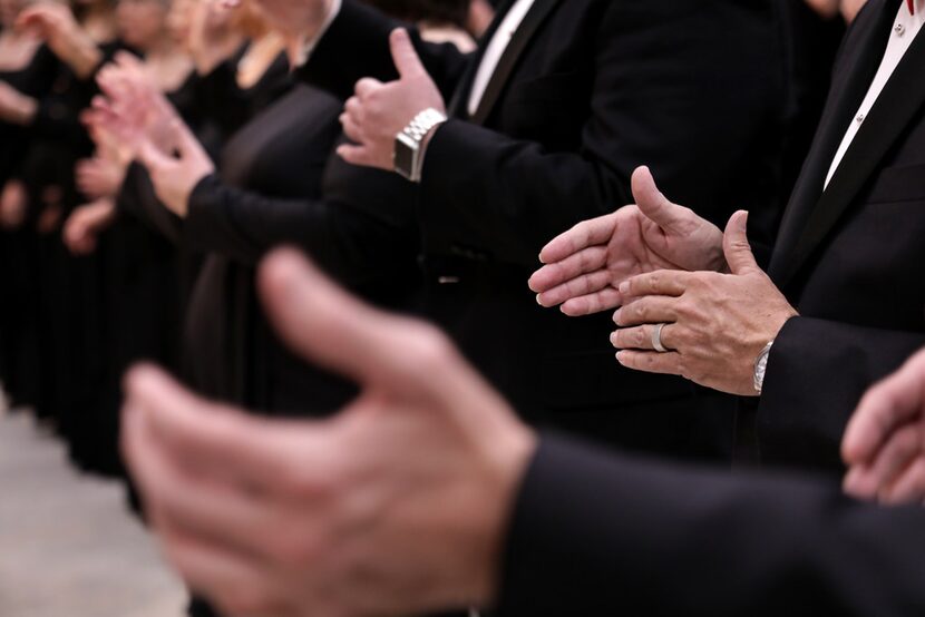 The Dallas Symphony Chorus warms up in their practice room before a performance at the...