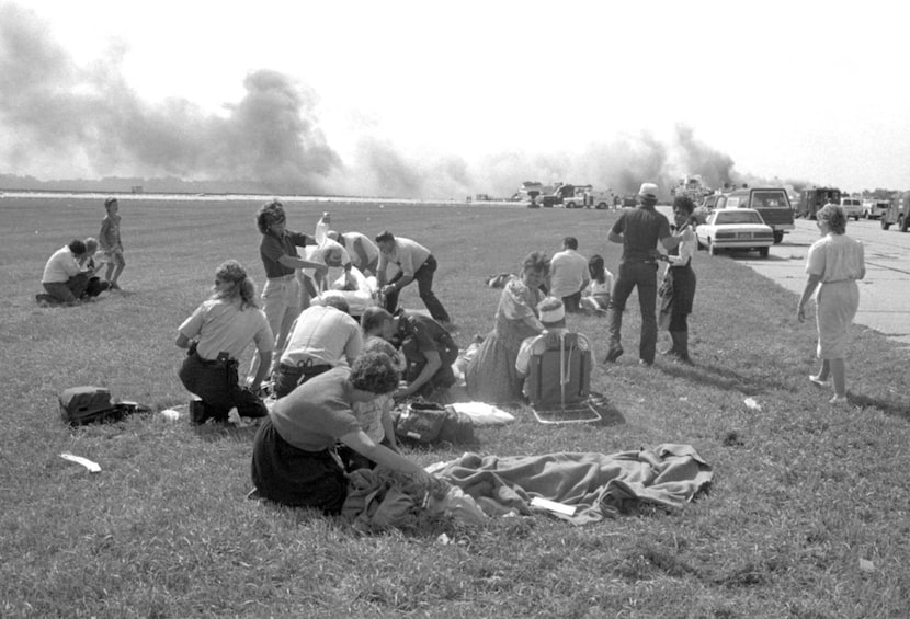 Emergency workers treat injured passengers from United Airlines Flight 232 after after the...