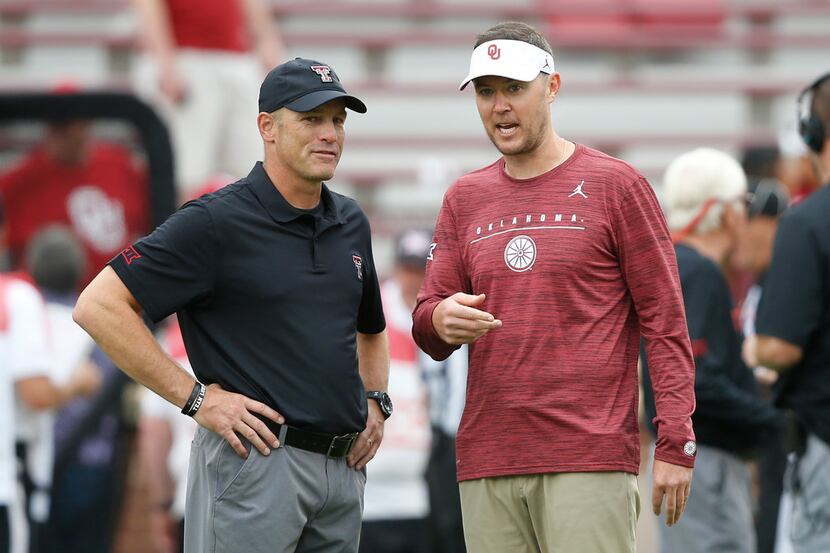 Texas Tech head coach Matt Wells, left, talks with Oklahoma head coach Lincoln Riley, right,...