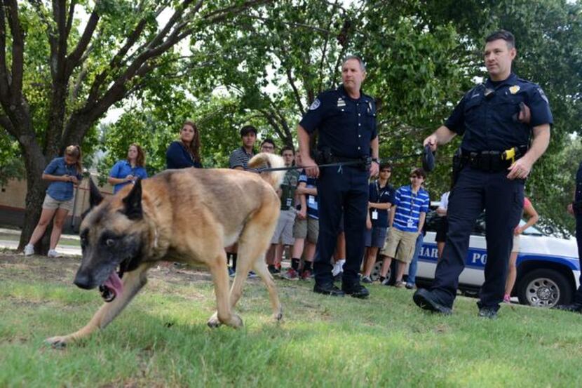 
Richardson Police officers Lee Rhinebarger (left) and Cory Wendling show students how Max,...