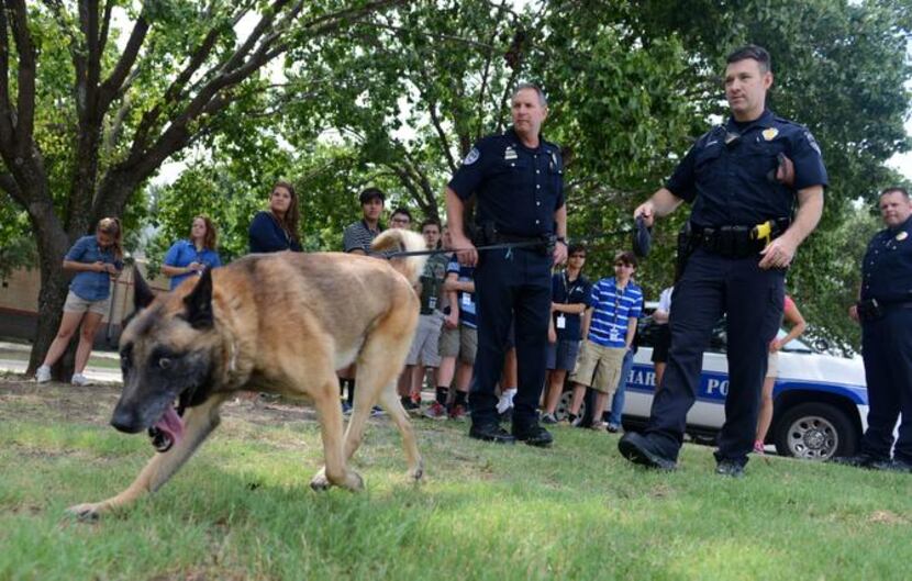 
Richardson Police officers Lee Rhinebarger (left) and Cory Wendling show students how Max,...