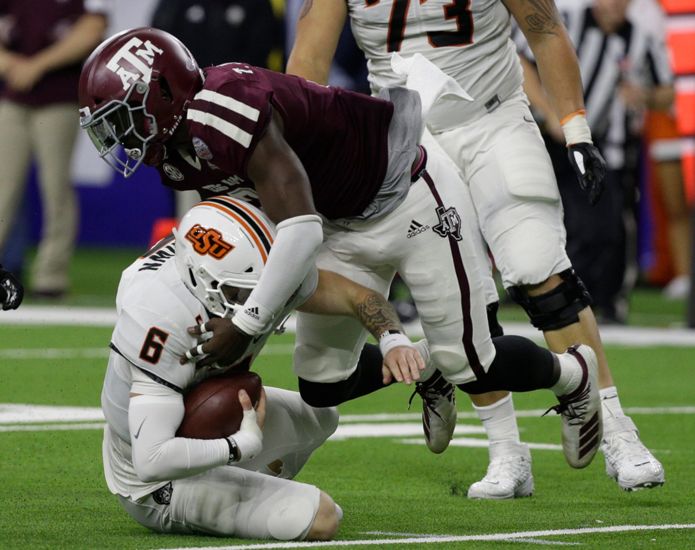 HOUSTON, TEXAS - DECEMBER 27: Dru Brown #6 of the Oklahoma State Cowboys is sacked by Tyree...