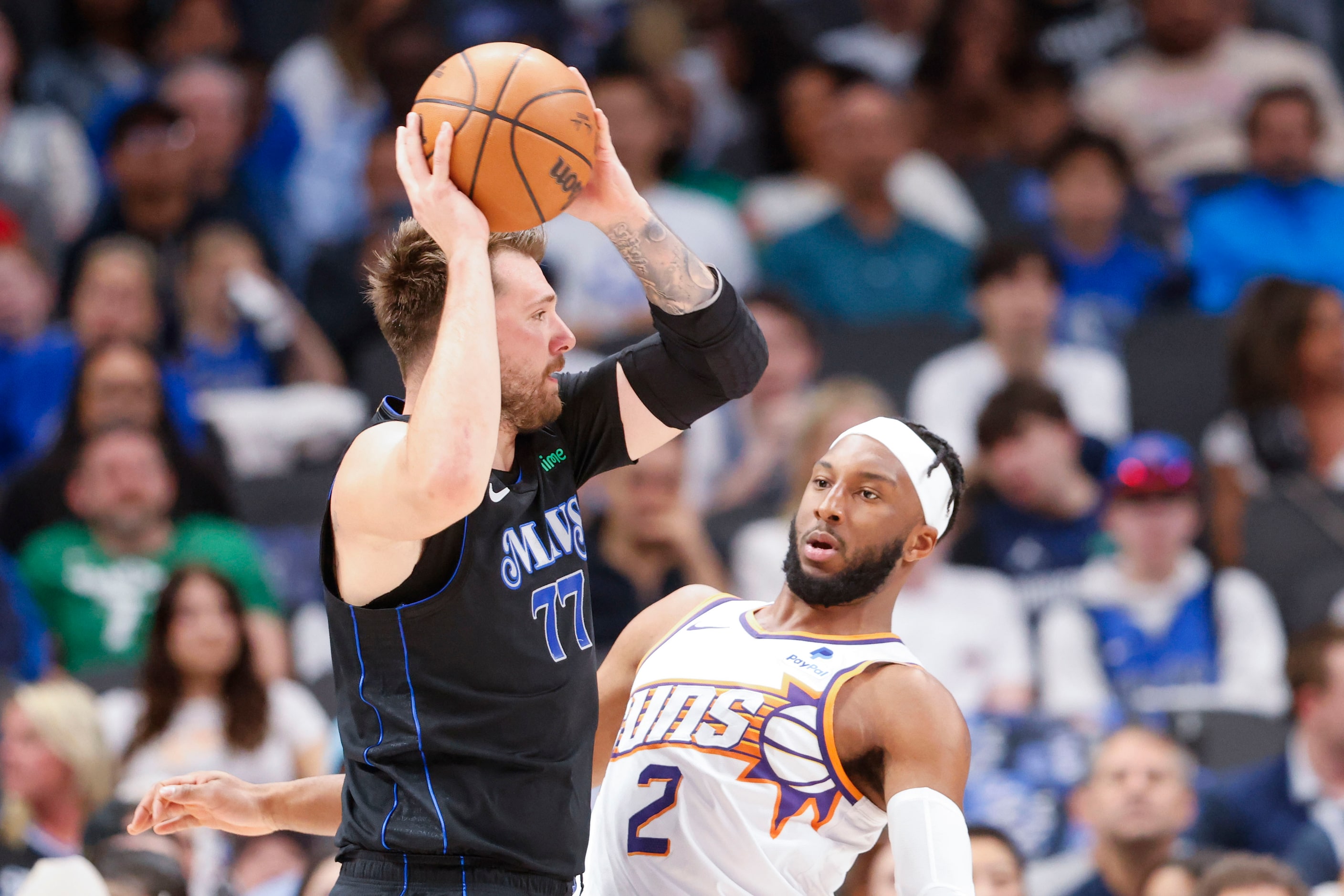 Dallas Mavericks guard Luka Doncic (left) looks to pass past Phoenix Suns forward Josh...