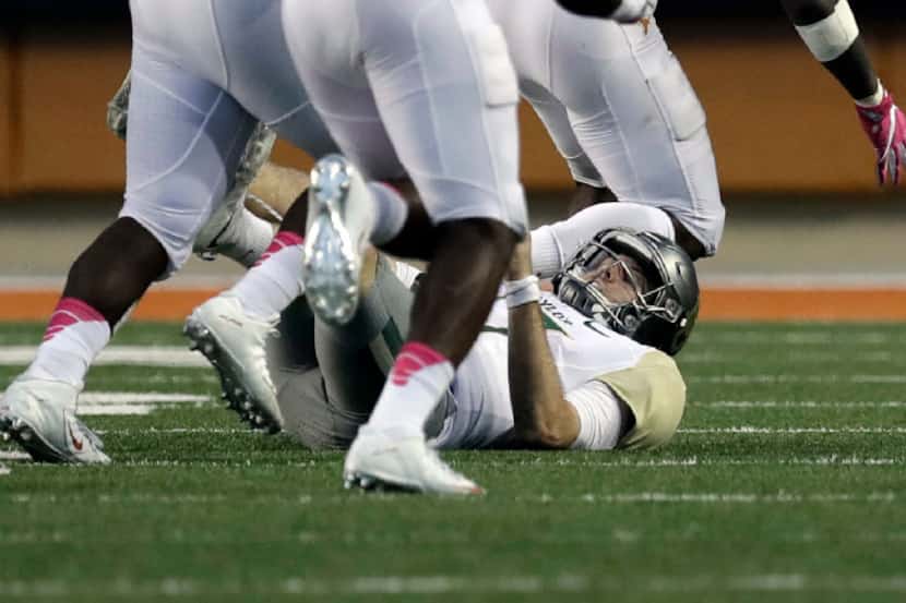 Baylor quarterback Seth Russell (17) falls to the turf after he was hit by Texas linebacker...