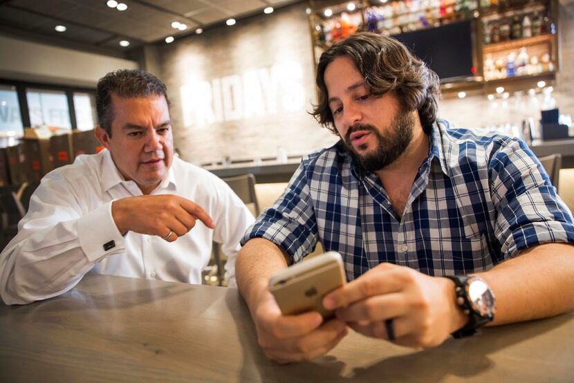 Ben Lamm (right), CEO and co-founder of Conversable, demonstrates the use of a chatbot his...